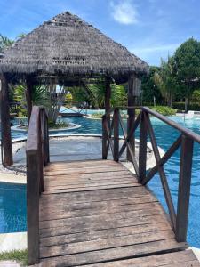 eine Holzbrücke über einen Pool in einem Resort in der Unterkunft Apartamento no resort in Barra de São Miguel
