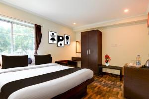Una habitación de hotel con una cama grande y una ventana. en Townhouse New Digha Formerly Hotel Coral, en New Digha