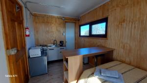 a small kitchen with a table in a tiny house at CABAÑA EL BUHO - ESMERALDA in Puerto Natales
