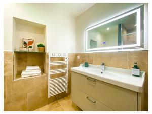 a bathroom with a sink and a mirror and towels at Maisons Mage Sauge in La Celle-sous-Gouzon +28 photos