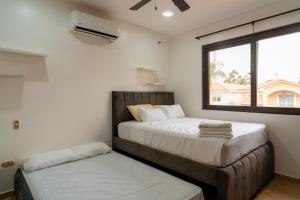 a bedroom with two beds and a window at Via Samborondón Ciudad Celeste, Tipo Mansión, 5 camas, 4 hab, piscina gym in SamborondÃ³n +140 photos