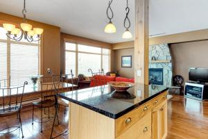 a kitchen and living room with a table and a couch at Glacier Lodge 106 in Big White +10 photos