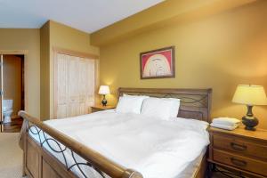 a bedroom with a large bed and two lamps at Glacier Lodge 106 in Big White