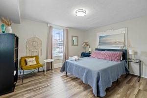 a bedroom with a bed and a chair and a window at CGV - Unique and Memorable 3BDR Stay in Columbus