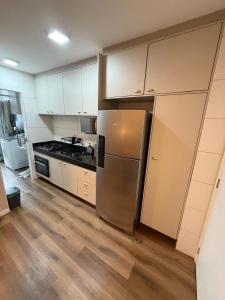 a kitchen with a stainless steel refrigerator and white cabinets at Apartamento Premium Lazer Completo, Rooftop e Academia in Belém +28 photos