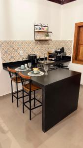 a kitchen with a table with chairs and wine glasses at Riquezas de Lavras Novas - Chalé Safira in Lavras Novas +2 photos