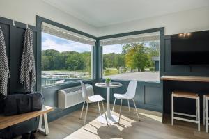 a living room with a table and chairs and a large window at Lakelyn Lodge in Lakeville