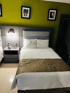 a bedroom with a green wall and a bed at Hotel El Rancho in Sabinas Hidalgo +5 photos
