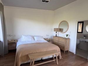 a bedroom with a bed and a table and a mirror at Aires de Capilla in Capilla del Señor