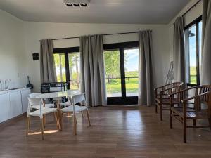 Una cocina y un comedor con mesa y sillas. en Aires de Capilla, en Capilla del Señor