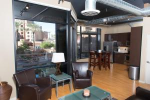斯科茨3rd Avenue Lofts located in Old Town Scottsdale的客厅配有椅子和桌子,设有大窗户