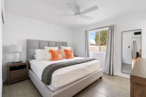 Un dormitorio con una cama con almohadas naranjas y una ventana. en 4BR 3BA Tempe Home with Pool, Hot Tub, Putting Green, & Game Room, en Tempe Junction 51 fotos más