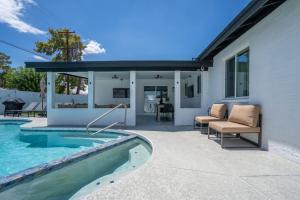 Un patio trasero con piscina y una casa. en 4BR 3BA Tempe Home with Pool, Hot Tub, Putting Green, & Game Room, en Tempe Junction