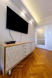 un soggiorno con una TV a schermo piatto su una parete di Chain Bridge Studio a Budapest