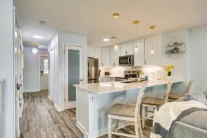 a kitchen with white cabinets and a counter with chairs at Poolside Fun + Oceanfront Bliss: Kure Beach Haven! in Kure Beach