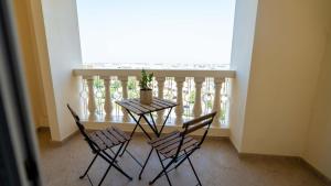 d'une table, de chaises et d'une plante sur le balcon. dans l'établissement Village View Serenity by Hala Homes, à Ras al Khaimah