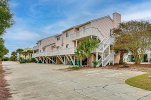 a large apartment building with a parking lot at Poolside Fun + Oceanfront Bliss: Kure Beach Haven! in Kure Beach
