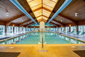 an indoor swimming pool with a large ceiling at Poolside Fun + Oceanfront Bliss: Kure Beach Haven! in Kure Beach