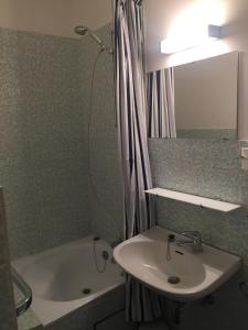 une salle de bain avec un lavabo, une baignoire et une douche dans l'établissement Résidence Sparrow, à Coxyde 21 autres photos