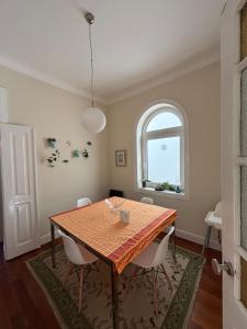 een eetkamer met een tafel en een raam bij Casa Clara in Aveiro