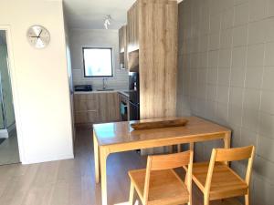 una cucina con un tavolo di legno e due sedie di Sunny Tidy Corner in Ellerslie ad Auckland Altre 7 foto