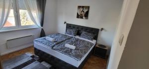 a bedroom with a bed with a black and white comforter at Apartman Bear Vinkovci in Vinkovci