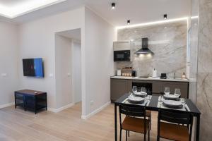 a kitchen with a table with chairs and a stove at Casetta 48 in Lido di Ostia +12 photos