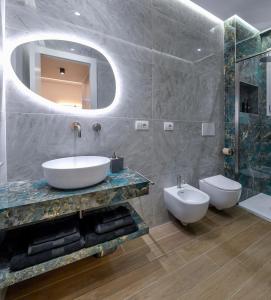 a bathroom with a sink and a toilet and a mirror at Casetta 48 in Lido di Ostia