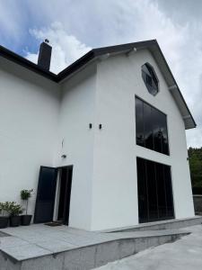 a white house with black windows at WHITE HORTENZIA Guesthouse in Batumi