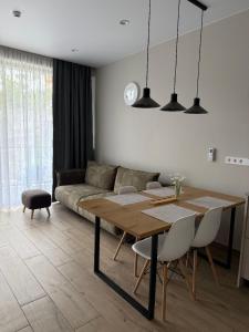 a living room with a table and a couch at WHITE HORTENZIA Guesthouse in Batumi