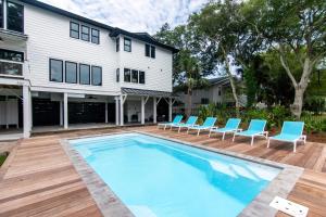 a swimming pool with chairs and a house at T-Time in Edisto Island
