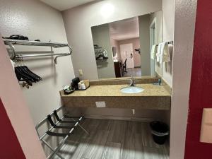 een badkamer met een wastafel en een spiegel bij The Heritage Inn, Inc in Huntingdon