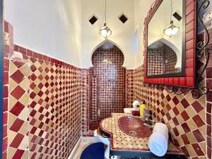 a bathroom with a sink and a mirror at Tangier Heritage Riad - Bay Views & Kasbah in Tangier +52 photos