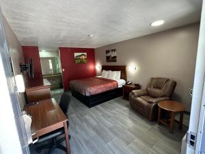 een hotelkamer met een bed en een stoel bij The Heritage Inn, Inc in Huntingdon