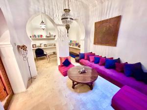 a living room with a purple couch and a table at Tangier Heritage Riad - Bay Views & Kasbah in Tangier