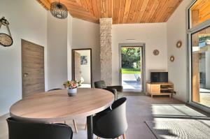 Un comedor con mesa y sillas de madera. en L Etel - spa extérieur vue étoiles de la chambre et vélos électriques, en Mortagne-sur-Gironde 19 fotos más