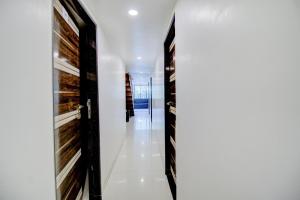 a hallway of a house with black doors and white walls at Hotel O Blue Light Near Gateway Of India Mumbai in Mumbai +25 photos
