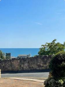 a stone retaining wall next to a road at New Waverleys Retreat Stunning Loft Style Ventnor in Ventnor