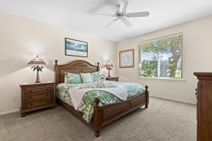 Un dormitorio con una cama y un ventilador de techo. en Hale Kaileia Kai - Peaceful Ground Floor Getaway, en Waikoloa