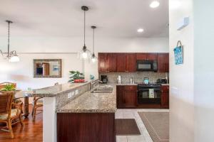 Una cocina con gabinetes de madera y encimera. en Hale Kaileia Kai - Peaceful Ground Floor Getaway, en Waikoloa