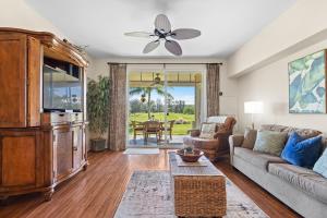 una sala de estar con un sofá y una mesa en Hale Kaileia Kai - Peaceful Ground Floor Getaway, en Waikoloa