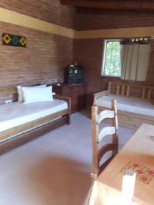 a room with two beds and a tv in it at Casa Sol Y Rio in Mina Clavero