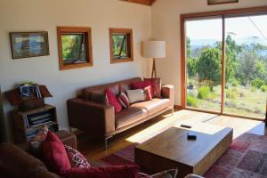 a living room with a couch and a coffee table at The Tree House in Alonnah +5 photos