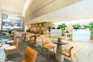 a restaurant with tables and chairs in a lobby at Grand Mercure Sao Paulo Vila Olimpia in Sao Paulo