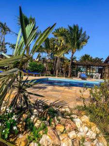 ein Swimmingpool mit Palmen im Hintergrund in der Unterkunft Eco Resort Vento Leste in Jericoacoara