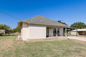 una pequeña casa blanca con un patio de césped en Walk to Historic Square Jacksboro Home with Yard, en Jacksboro