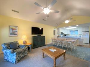 ein Wohnzimmer mit einer Couch, einem Sessel und einem Tisch in der Unterkunft Petty House in Edisto Island