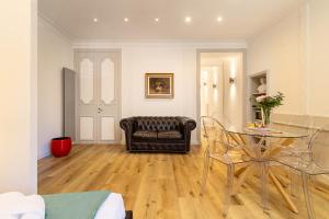 ein Wohnzimmer mit einem Glastisch und einem Ledersessel in der Unterkunft Crispi 30 Stylish Apartment in Rom