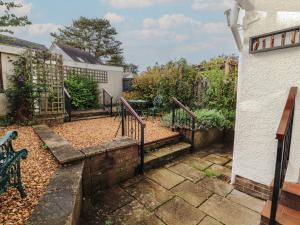 a garden with stairs and a fence and a building at Riverside Cottage in Cockermouth