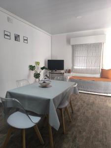 Oasis urbano! Apartamento Geminis complejo في سان نيكولاس دي لوس أرويوس: غرفة معيشة بها طاولة وكراسي وسرير +29 صورة